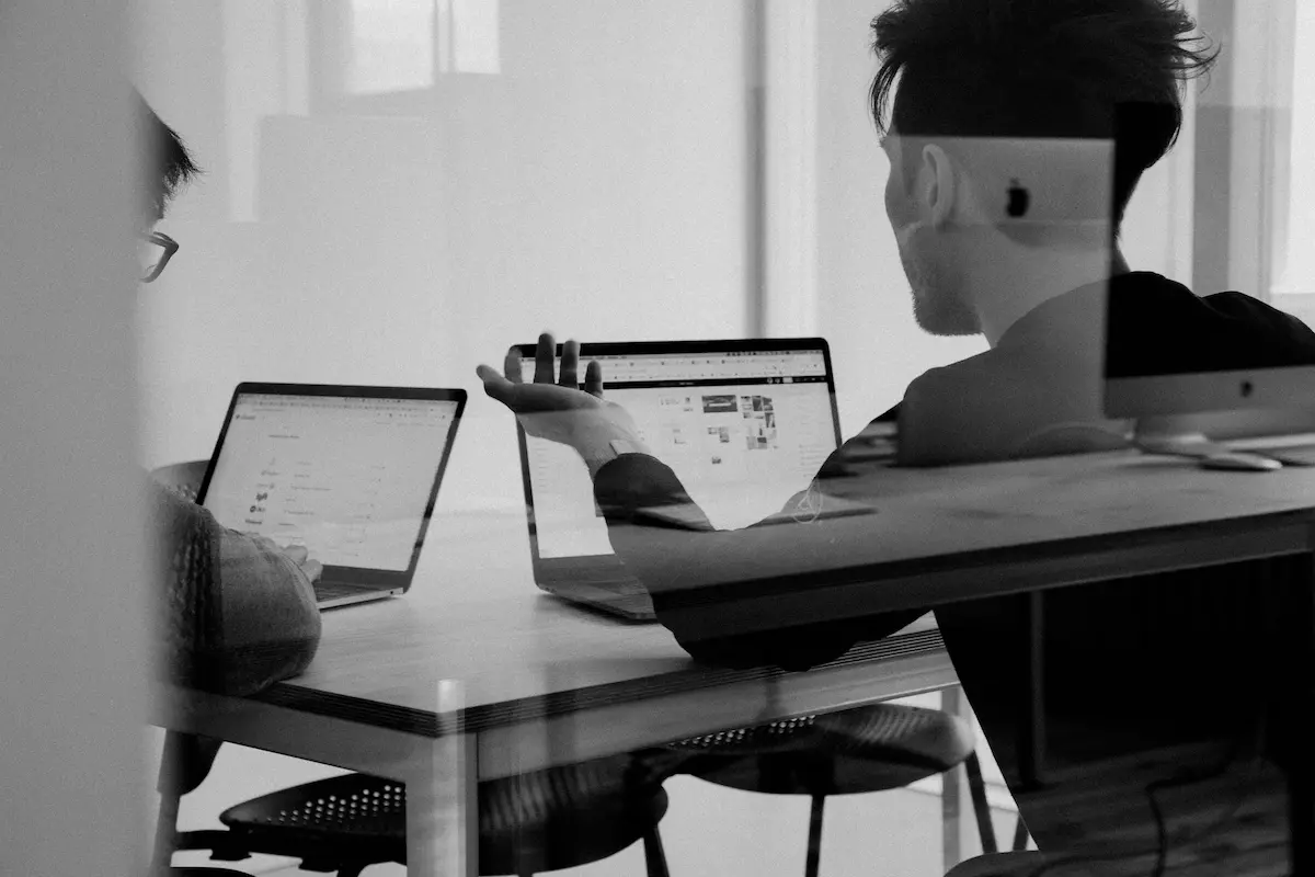 Two people working on laptops together