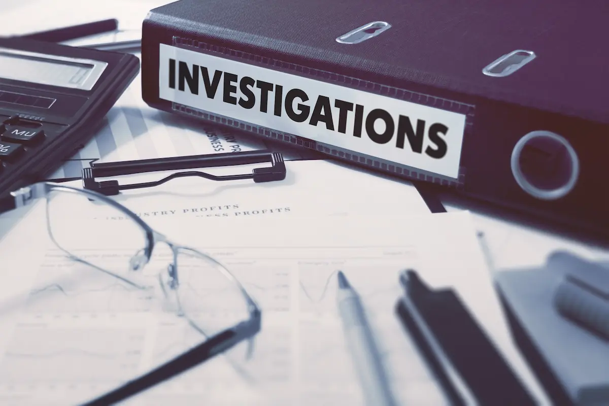 Private investigator agency case files and investigation documents organized on an office desk.